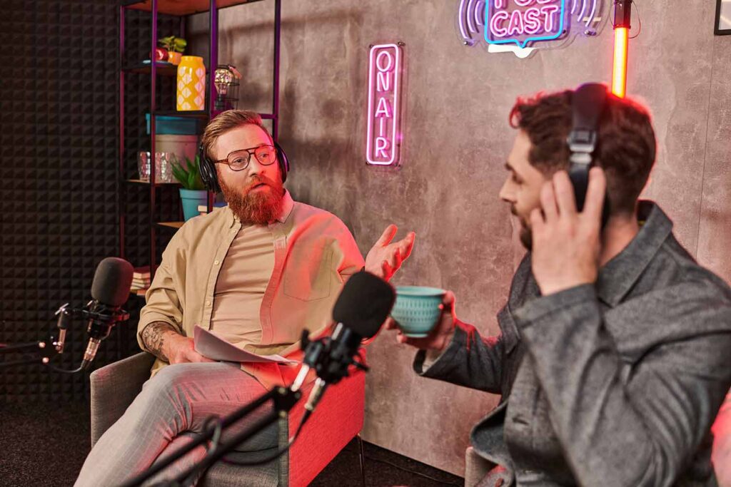 produkcja podcastu firmowego - dwie osoby rozmawiają w studiu podcastowym